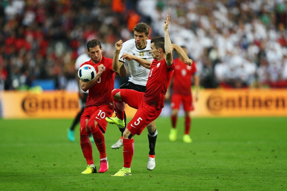 Thomas Müller face à deux Polonais